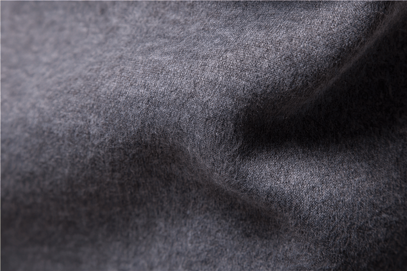 Close-up texture of thick gray hoodie fabric showing soft, cozy material.